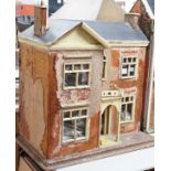 An English back-opening furnished dolls’ house, c.1900, modelled as a double-fronted brick villa,