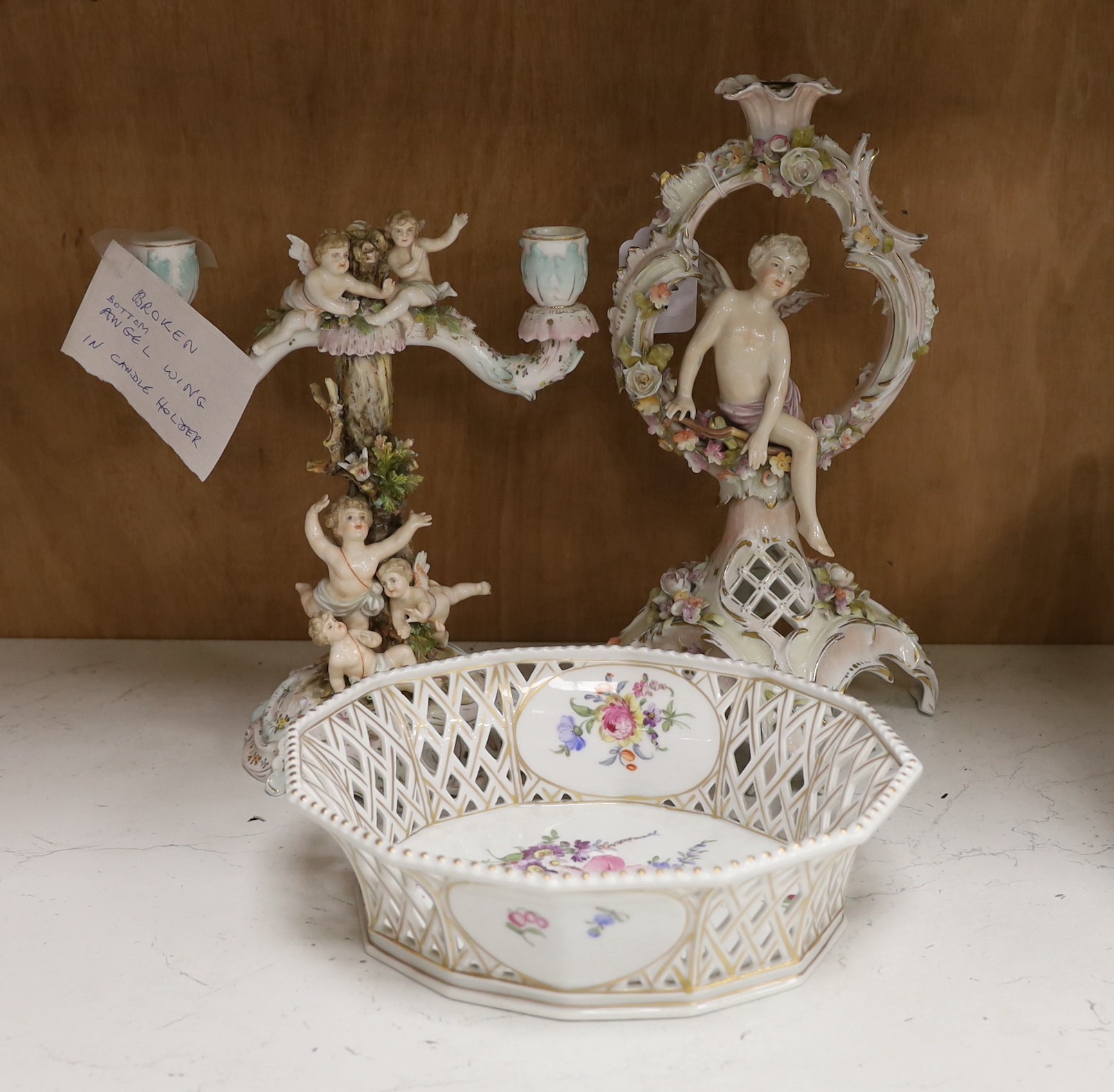 A Volkstedt porcelain candelabrum decorated with cherubs, a candlestick and an octagonal basket