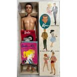A boxed Ken doll, with another box of Ken clothing