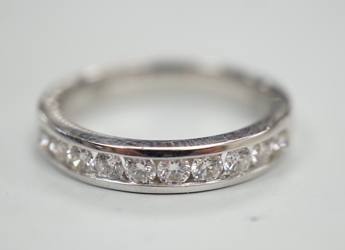 A modern 18k white metal and ten stone channel set diamond half eternity ring, size L/M, gross