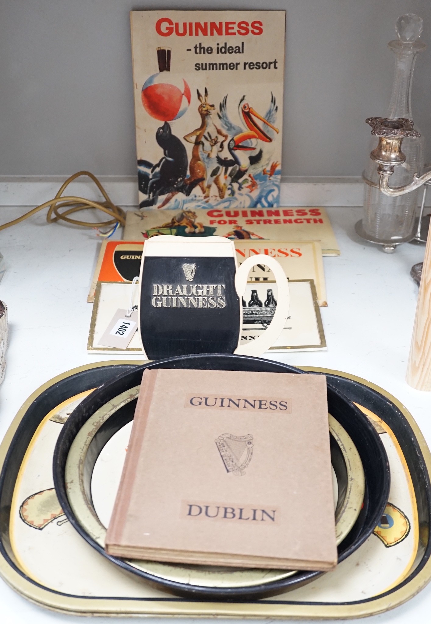 Five Guinness advertising signs, mirror, trays and a book - St. James’s Gate Brewery History and