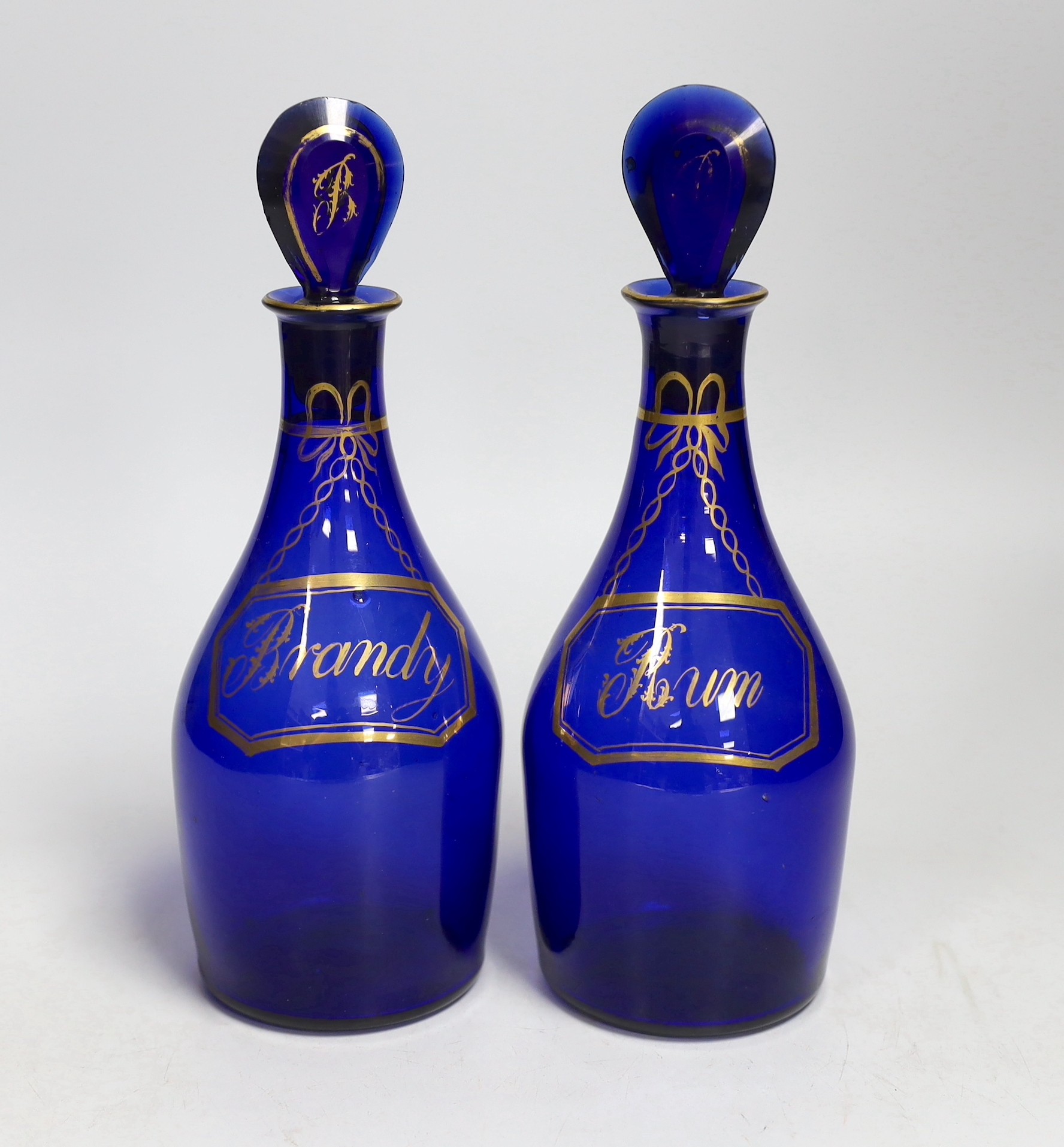 A pair of George III Bristol blue glass and gilt decanters, ‘Brandy’ and ‘Rum’. 23cm tall