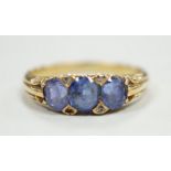 An early 20th century 18ct and three stone sapphire set half hoop ring, with diamond chip spacers,