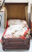 An Armand Marseille 390 A 11/2 M porcelain doll and a half tester wooded bed, bed 55cms deep x 55cms