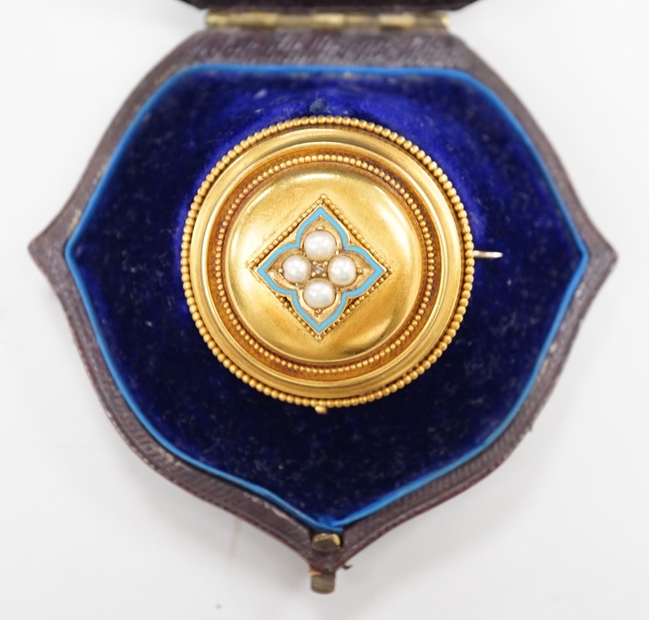 A cased Victorian yellow metal, enamel and split pearl set circular mourning pendant brooch, the