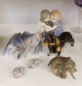 A Royal Copenhagen figure group of two children hugging a puppy, two other dog ornaments, three fish