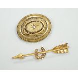 An early 20th century yellow metal, and seed pearl set arrow and horse shoe brooch, 60mm and a