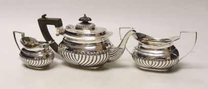 An Edwardian three piece demi-fluted silver tea set, Birmingham, 1905, gross 21.1oz.