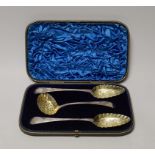 A cased set of two George III parcel gilt silver spoons and a matching sifter spoon, George Burrows,