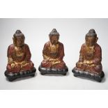 A set of three Chinese polychrome lacquered wood seated figures of Buddha, 19cm