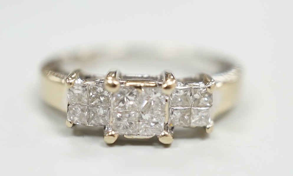 A modern 18ct white gold and triple princess cut diamond cluster set dress ring, size K, gross