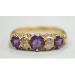 An 18ct, three stone amethyst and four stone diamond set half hoop ring, size Q/R, gross weight 4