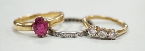 An 18ct and solitaire synthetic? ruby set ring, an 18ct and three stone diamond ring and a white