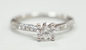 A modern platinum and single stone diamond ring, with diamond set shoulders and accompanying