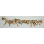 A 9ct charm bracelet, hung with assorted mainly 9ct gold charms, gross weight 46.1 grams.