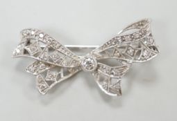 A white metal and diamond cluster set ribbon bow brooch, 36mm, gross weight 4 grams.