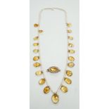 An Edwardian twenty one graduated oval cut citrine set seed pearl necklace (a.f) clasp loose,