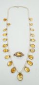 An Edwardian twenty one graduated oval cut citrine set seed pearl necklace (a.f) clasp loose,