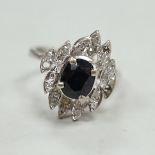 A modern 750 white metal, sapphire and diamond cluster set dress ring (two diamonds missing), size