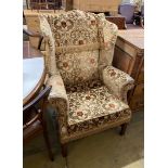 A George III style upholstered wing armchair, width 86cm, depth 70cm, height 112cm