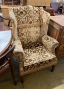 A George III style upholstered wing armchair, width 86cm, depth 70cm, height 112cm