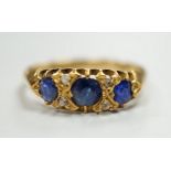 An Edwardian 18ct gold and graduated three stone sapphire set half hoop ring, with four stone rose