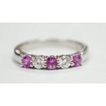 A modern 18ct white gold, three pink stone and two stone diamond set half hoop ring, size M, gross