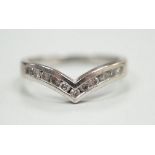 A modern 18ct white gold and channel set diamond chip wishbone shaped ring, size M, gross 3.4