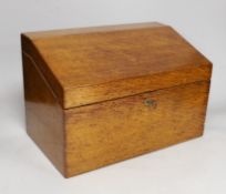 A 19th century oak stationery casket, with a sectional fitted interior and leather compartment for