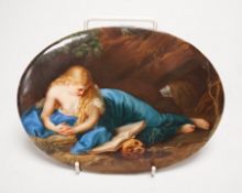 A 19th century painted porcelain oval plaque of a reclining lady reading a book. The reverse stamped