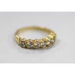 A modern 750 yellow metal and seven stone diamond set half hoop ring, size O, gross weight 3.2