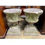 A pair of circular reconstituted campana garden urns with floral swagged bodies, diameter 59cm,