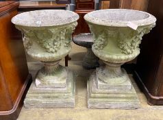 A pair of circular reconstituted campana garden urns with floral swagged bodies, diameter 59cm,