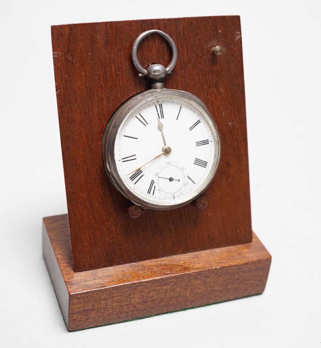 A silver pocket watch and holder