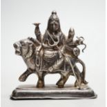 A Buddhist white metal group of a Bodhisattva riding a lion, 8cm tall