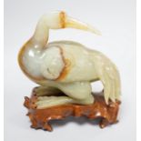 A Chinese green and russet jade figure of a crane, 11.5cm long, wood stand Provenance - the former