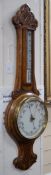 An Edwardian carved oak aneroid wheel barometer, 85cm *Please note the sale commences at 9am.