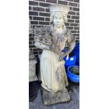 A reconstituted stone garden ornament of a female figure with a sheaf of corn on square plinth base,