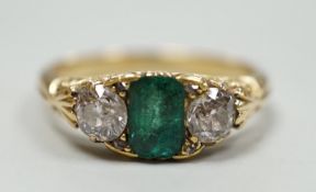 An early 20th century yellow metal, emerald and diamond set three stone ring, size L, gross weight