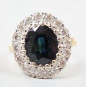 A 1970's? 18ct gold, single stone oval cut sapphire and illusion set diamond cluster ring, size O/P,