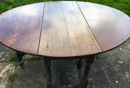 An 18th century oak gateleg dining table, the turned underframe with traces of old paint, length