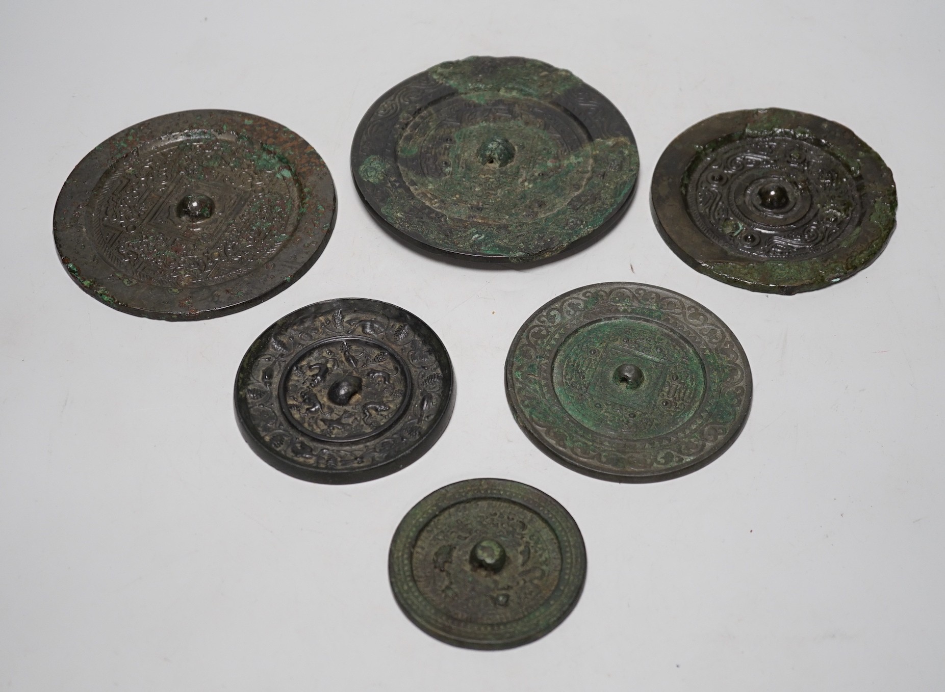 A group of six Chinese archaic bronze mirrors, including two Han dynasty TLV mirrors, and a Tang