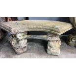 A reconstituted stone curved garden bench with dolphin supports, length 98cm, depth 46cm, height
