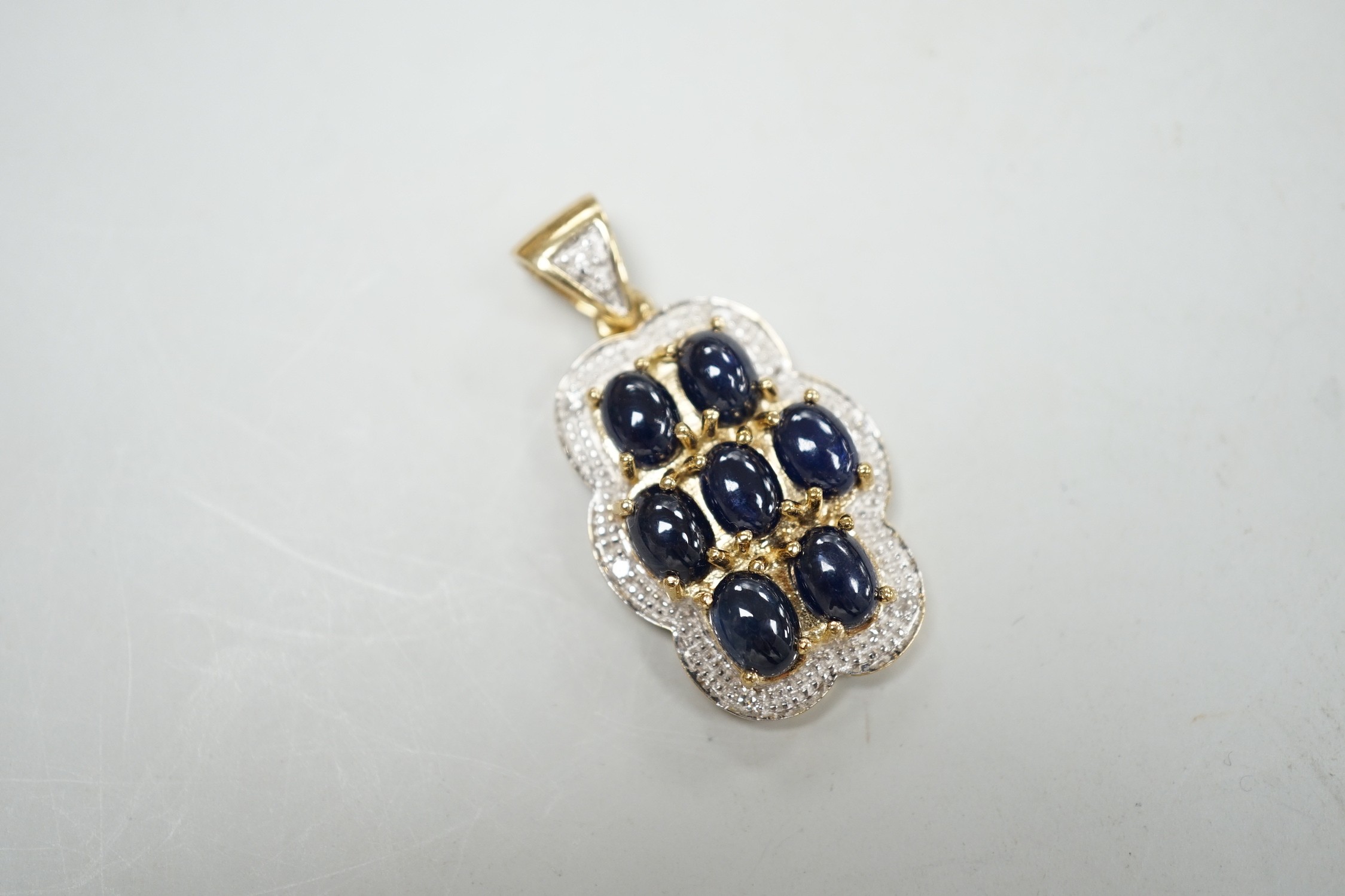 A modern 9ct gold, cabochon sapphire cluster and diamond chip set shaped oval pendant, overall 37mm, - Image 2 of 2