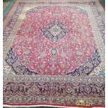 A Persian red ground carpet, 377 x 291cm, some bleach stains *Please note the sale commences at