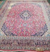 A Persian red ground carpet, 377 x 291cm, some bleach stains *Please note the sale commences at