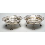 A pair of George VI pierced silver fruit bowls, on quadruped supports, with shell feet, James