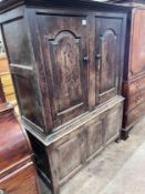 An early 18th century oak press cupboard two panelled doors and panelled base, width 127cm, depth