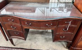 A 1920's serpentine mahogany kneehole dressing table, width 120cm, depth 61cm, height 76cm *Please