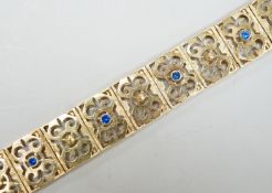A modern pierced yellow metal and blue paste set bracelet, 19cm gross weight 28.2 grams.
